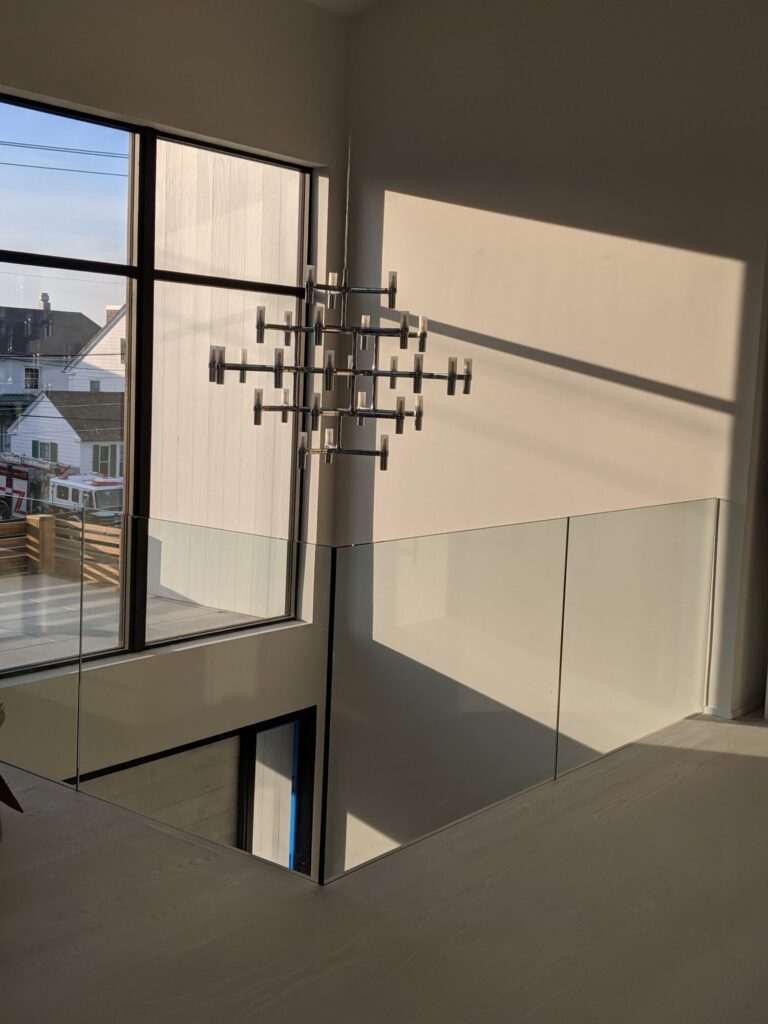Modern zig zag stair with glass panels and satin black metal rails, photo 5 of 9