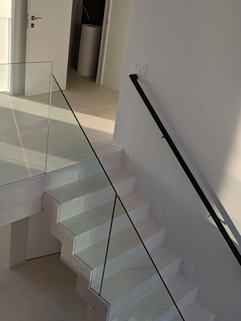 Modern zig zag stair with glass panels and satin black metal rails, photo 7 of 9