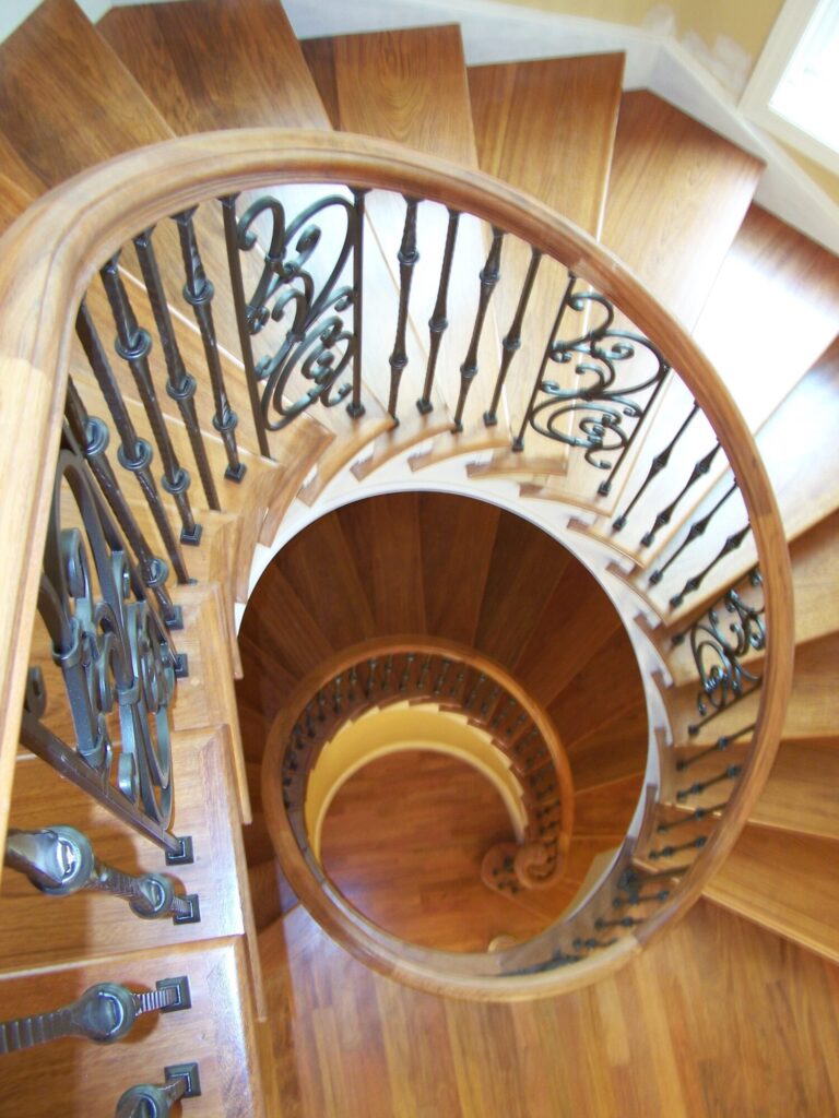 Traditional curved multi level staircase with iron balustrade: Brazilian cherry treads and handrails with tuscany iron. CNC tangent handrails, photo 1 of 18