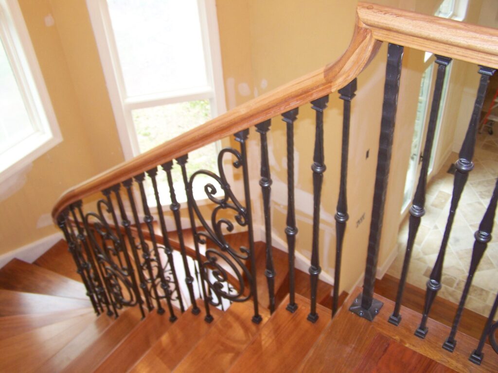 Traditional curved multi level staircase with iron balustrade: Brazilian cherry treads and handrails with tuscany iron. CNC tangent handrails, photo 18 of 18