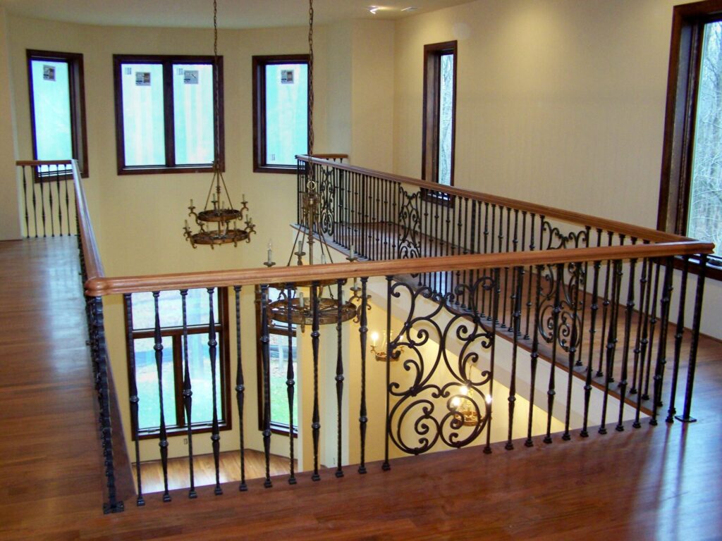 Traditional curved multi level staircase with iron balustrade: Brazilian cherry treads and handrails with tuscany iron. CNC tangent handrails, photo 17 of 18