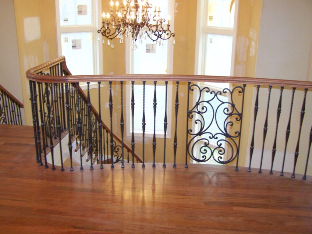 Traditional curved multi level staircase with iron balustrade: Brazilian cherry treads and handrails with tuscany iron. CNC tangent handrails, photo 16 of 18