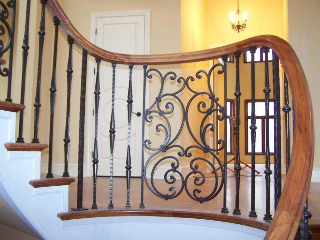 Traditional curved multi level staircase with iron balustrade: Brazilian cherry treads and handrails with tuscany iron. CNC tangent handrails, photo 14 of 18