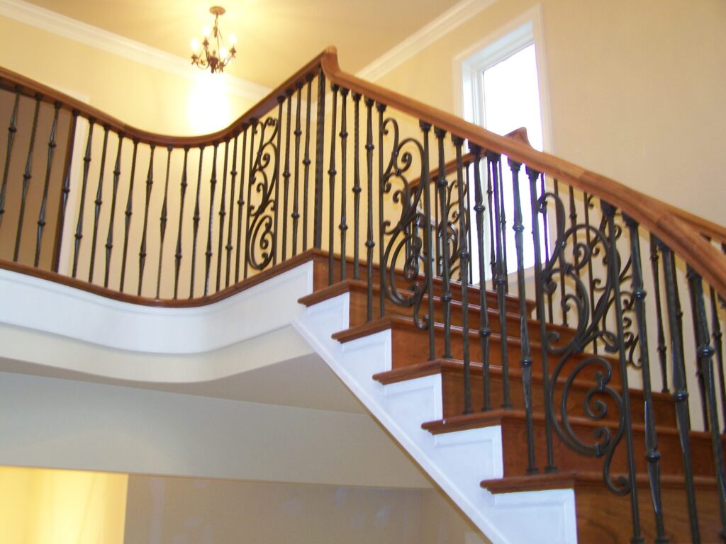 Traditional curved multi level staircase with iron balustrade: Brazilian cherry treads and handrails with tuscany iron. CNC tangent handrails, photo 13 of 18