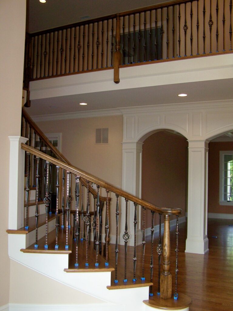 Traditional curved staircase with iron balustrade: Red oak treads and handrail, photo 8 of 11