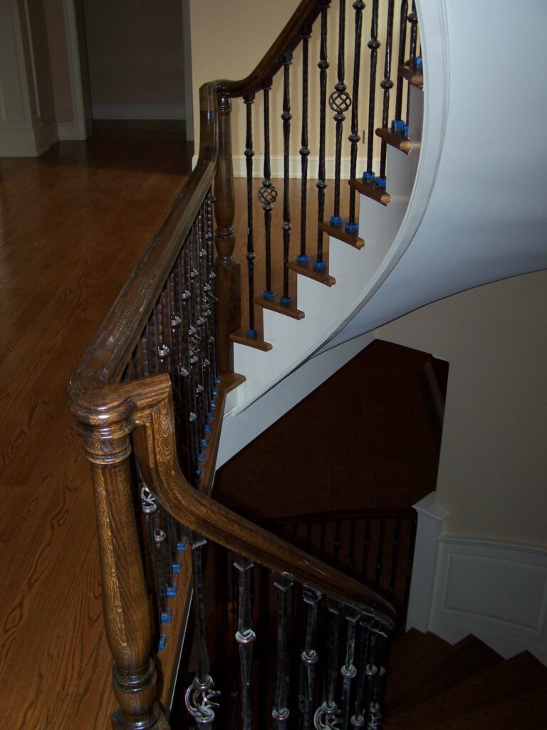 Traditional curved staircase with iron balustrade: Red oak treads and handrail, photo 6 of 11