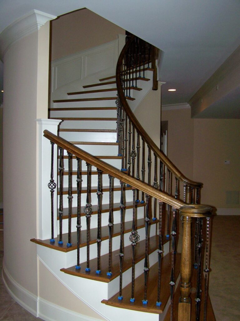 Traditional curved staircase with iron balustrade: Red oak treads and handrail, photo 5 of 11