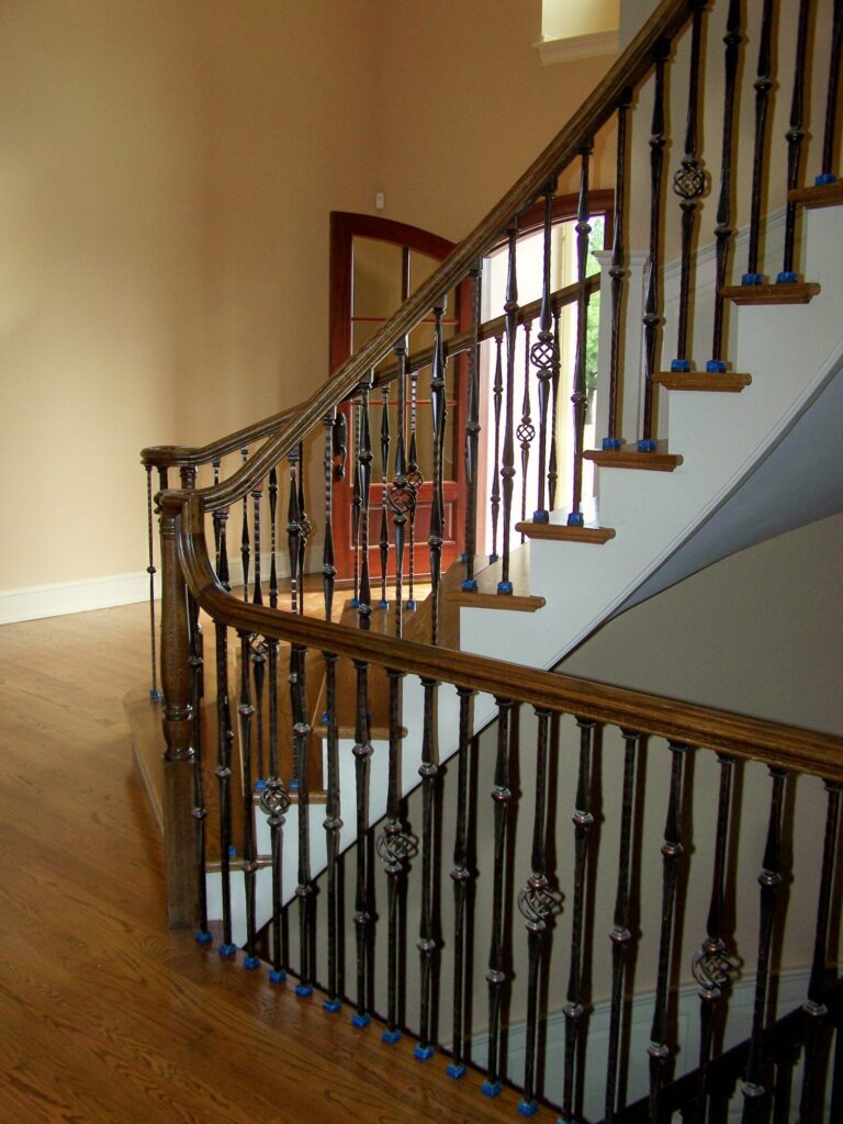 Traditional curved staircase with iron balustrade: Red oak treads and handrail, photo 2 of 11