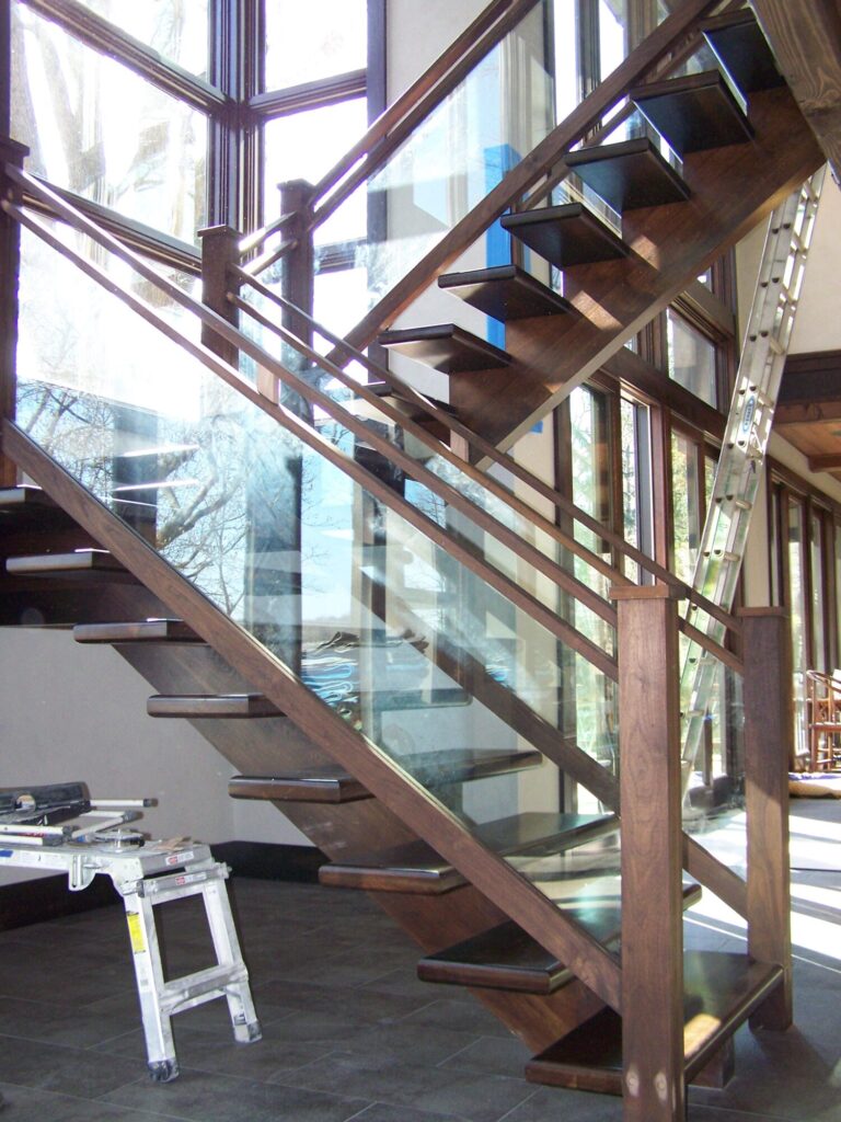 Modern solid walnut staircase with glass panel infill, photo 2 of 10