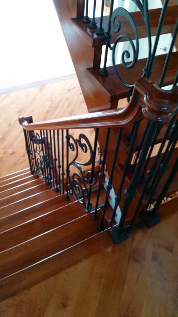 Modern open rise stair with vertical and scrolled balustrade: Solid maple stair and rail with iron balustrade, photo 7 of 21