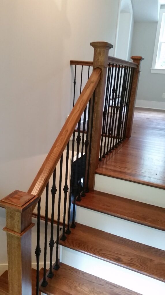 White oak square newel with simple cap and neck detail: Hammered rustic iron balustrade. Upper Makefield, PA, photo 2 of 17
