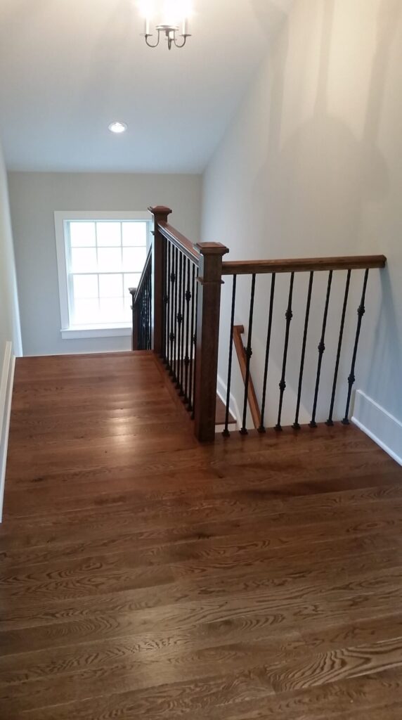 White oak square newel with simple cap and neck detail: Hammered rustic iron balustrade. Upper Makefield, PA, photo 3 of 17