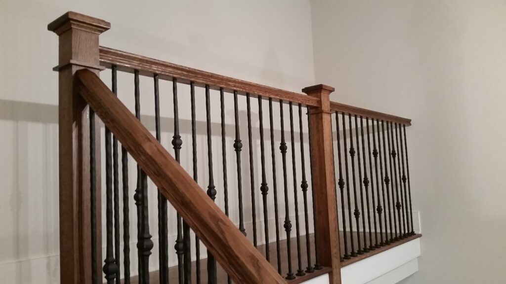 White oak square newel with simple cap and neck detail: Hammered rustic iron balustrade. Upper Makefield, PA, photo 10 of 17