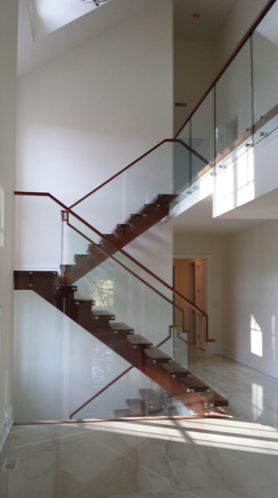 Center stringer stair with 3" thick treads, glass panels with wood top rail, photo 2 of 17
