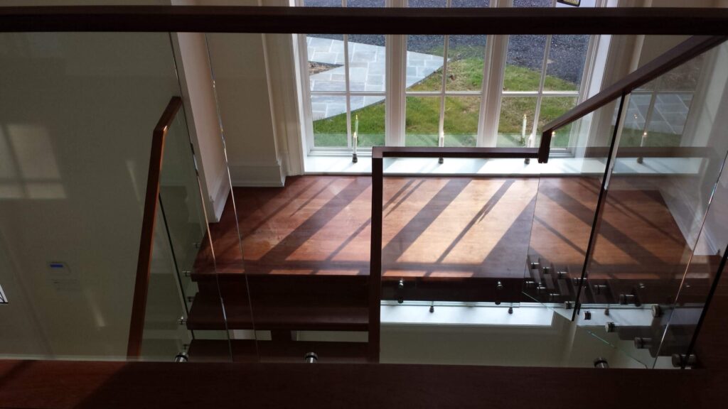 Center stringer stair with 3" thick treads, glass panels with wood top rail, photo 7 of 17