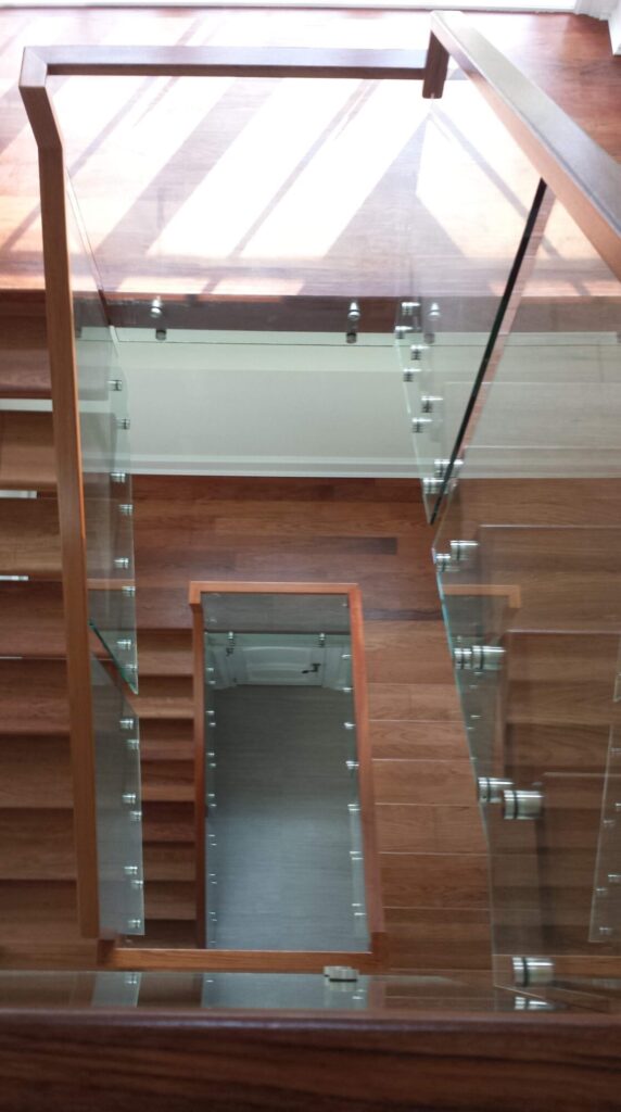 Center stringer stair with 3" thick treads, glass panels with wood top rail, photo 8 of 17