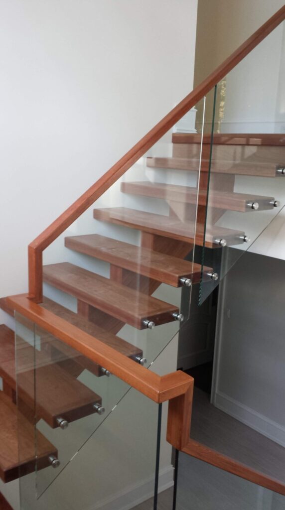 Center stringer stair with 3" thick treads, glass panels with wood top rail, photo 12 of 17