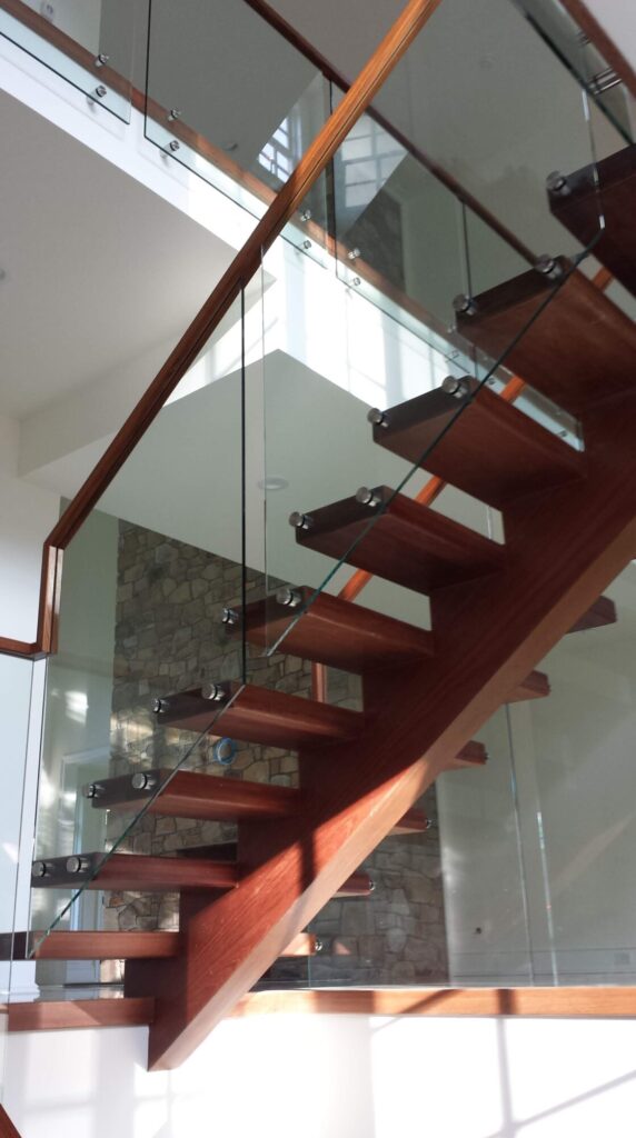 Center stringer stair with 3" thick treads, glass panels with wood top rail, photo 13 of 17
