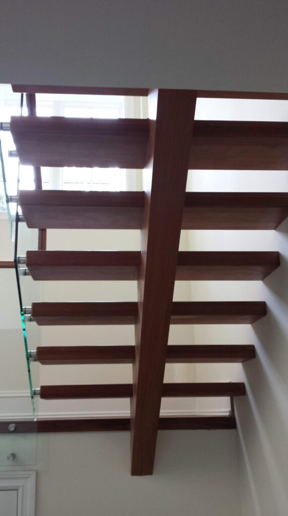 Center stringer stair with 3" thick treads, glass panels with wood top rail, photo 14 of 17