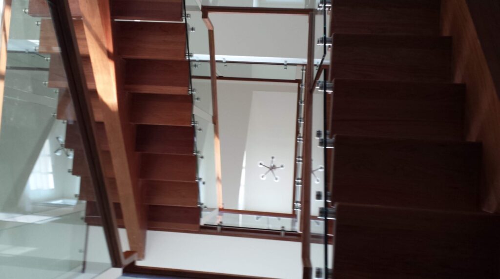 Center stringer stair with 3" thick treads, glass panels with wood top rail, photo 15 of 17