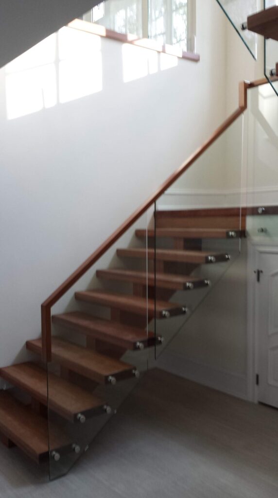 Center stringer stair with 3" thick treads, glass panels with wood top rail, photo 16 of 17