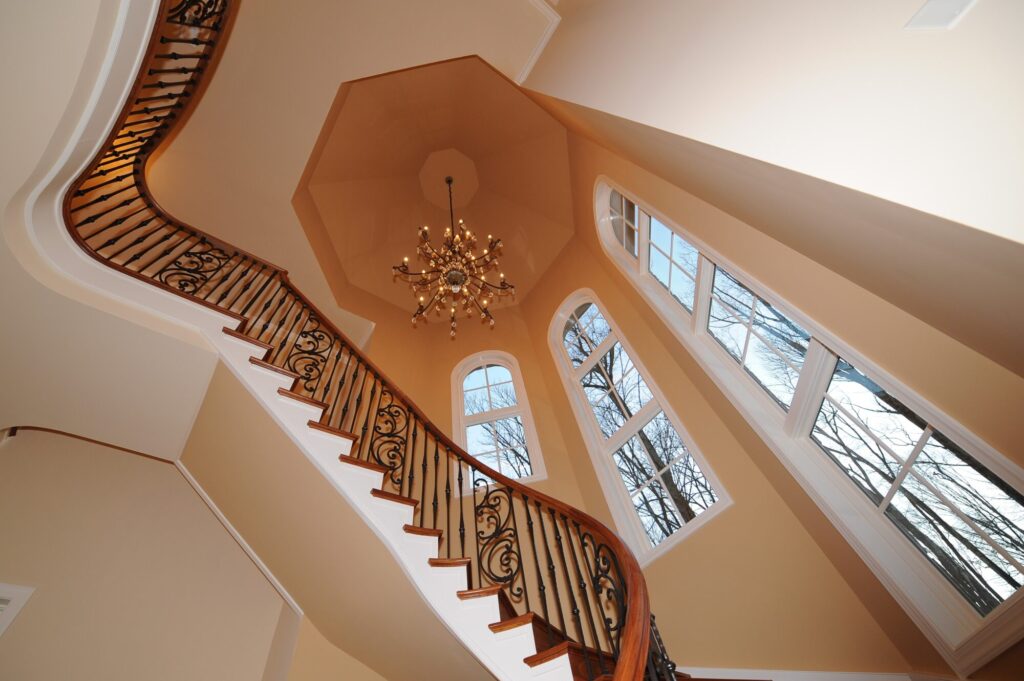 Traditional curved multi level staircase with iron balustrade: Brazilian cherry treads and handrails with tuscany iron. CNC tangent handrails, photo 7 of 18