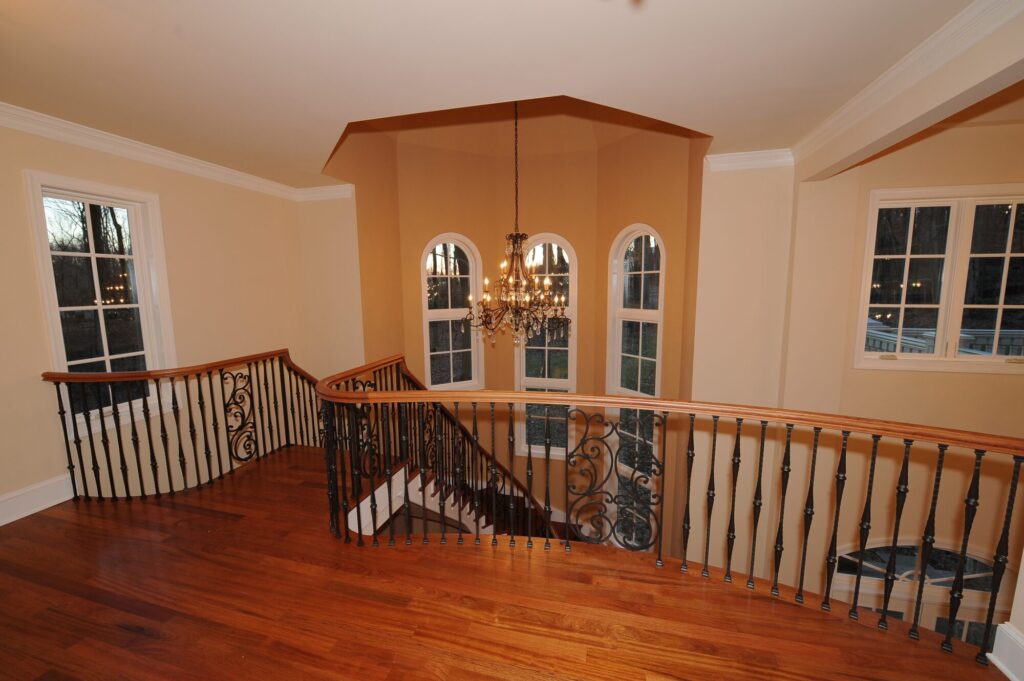 Traditional curved multi level staircase with iron balustrade: Brazilian cherry treads and handrails with tuscany iron. CNC tangent handrails, photo 4 of 18