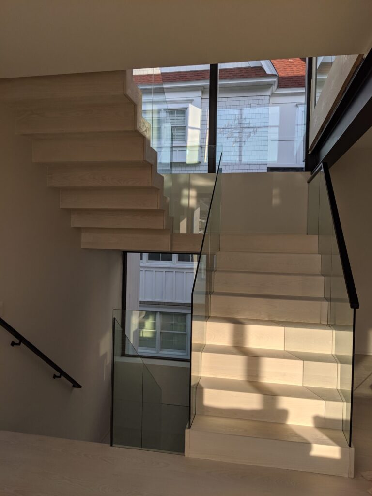 Modern zig zag stair with glass panels and satin black metal rails, photo 9 of 9