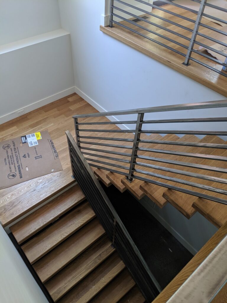 Mono stringer stair with horizontal clear coated metal rails, photo 1 of 6