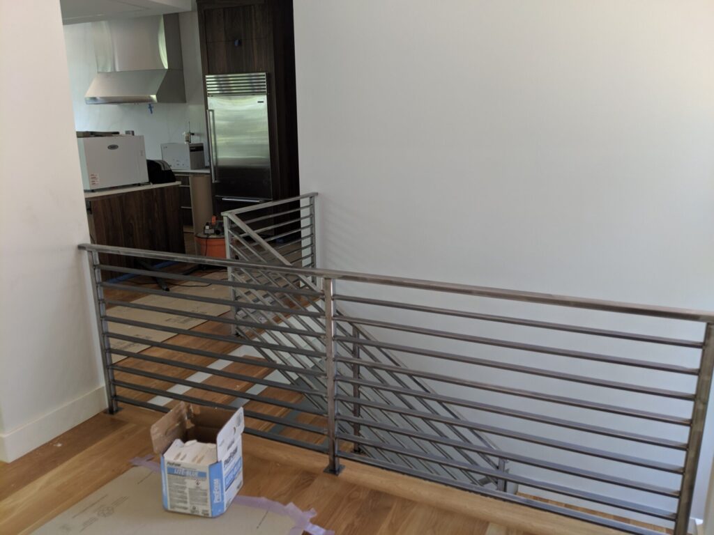 Mono stringer stair with horizontal clear coated metal rails, photo 2 of 6