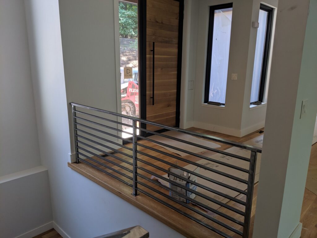 Mono stringer stair with horizontal clear coated metal rails, photo 4 of 6